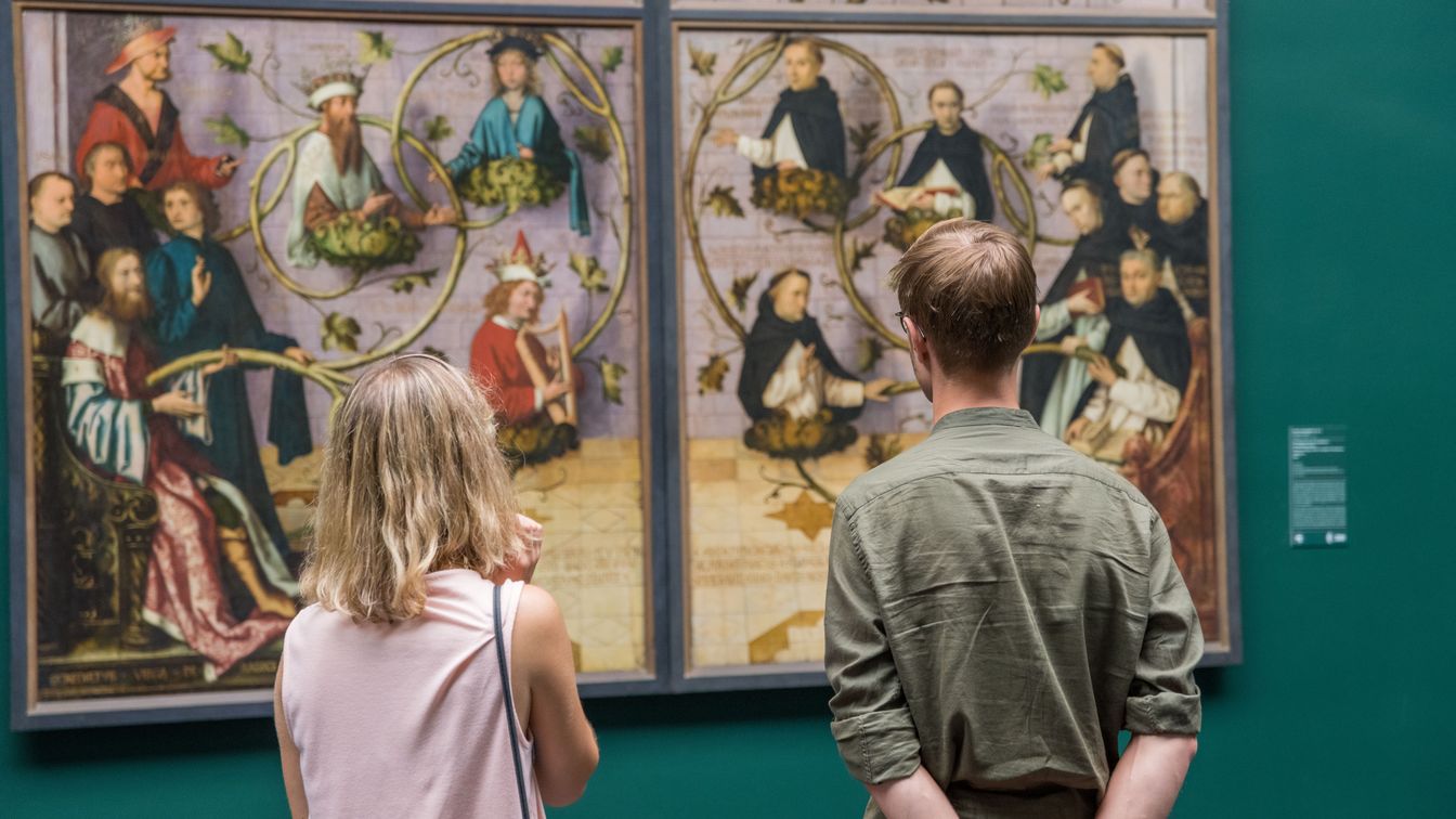 Zwei Besucher vor mehrteiligem Gemälde im Museum
