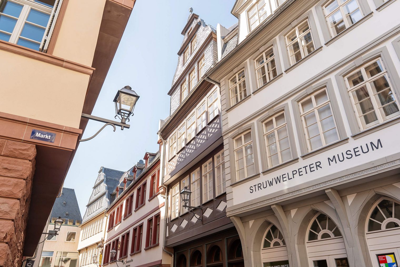 Blick auf historische Gebäude im traditionellen Stil der Altstadt. Im Vordergrund das Struwwelpeter-Museum mit auffälliger Beschriftung auf der Fassade.