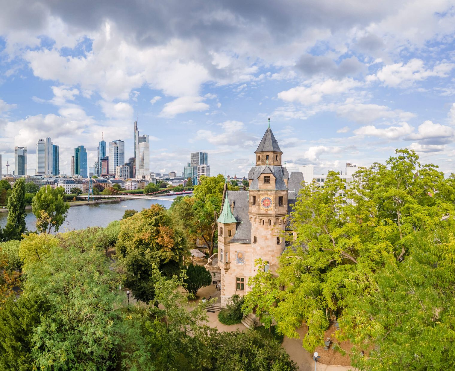 Blick auf das Liebighaus von schräg oben, dahinter der Main und die Frankfurter Skyline.