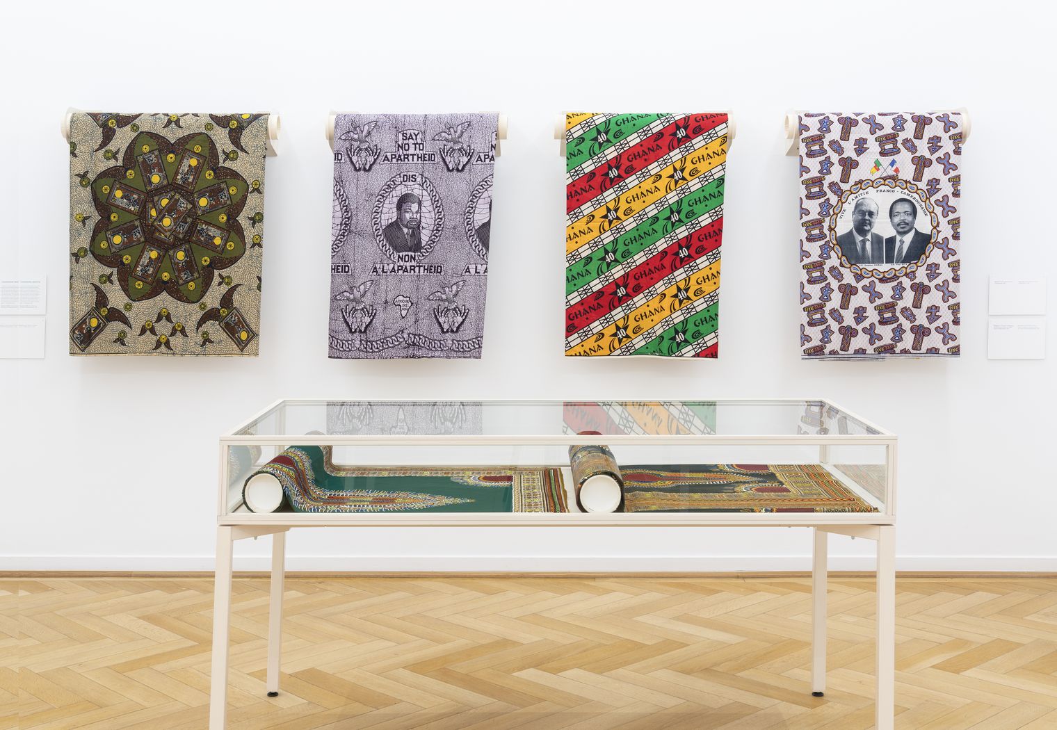 Ausstellung mit bedruckten Stoffbahnen und Vitrine im Museum Frankfurt